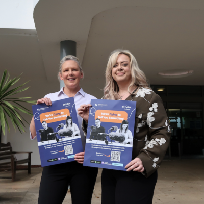 Charlotte Mills, Community Fundraiser, and Lorraine Ward, Regional Manager, holding We're Dying to Tell You Something podcast posters at St Giles Hospice