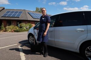 St Giles Hospice nurse Leia Roden standing with equipment case beside a car, ready for a Rapid Response visit
