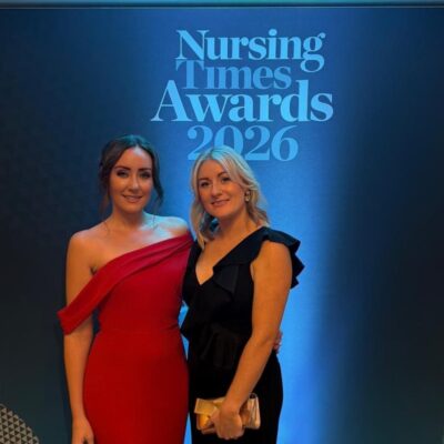 Charlotte Lowbridge in a red dress and Rebecca Powell from St Giles Hospice at the Nursing Times Awards 2026